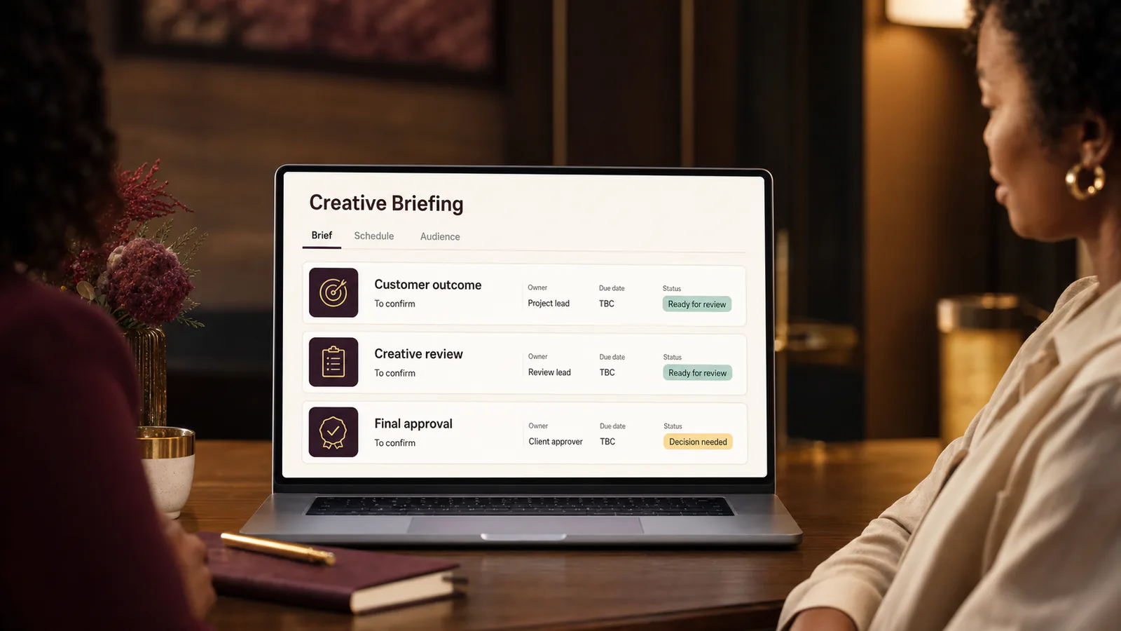 A project manager leads a creative-team briefing using a clear brief and delivery schedule.